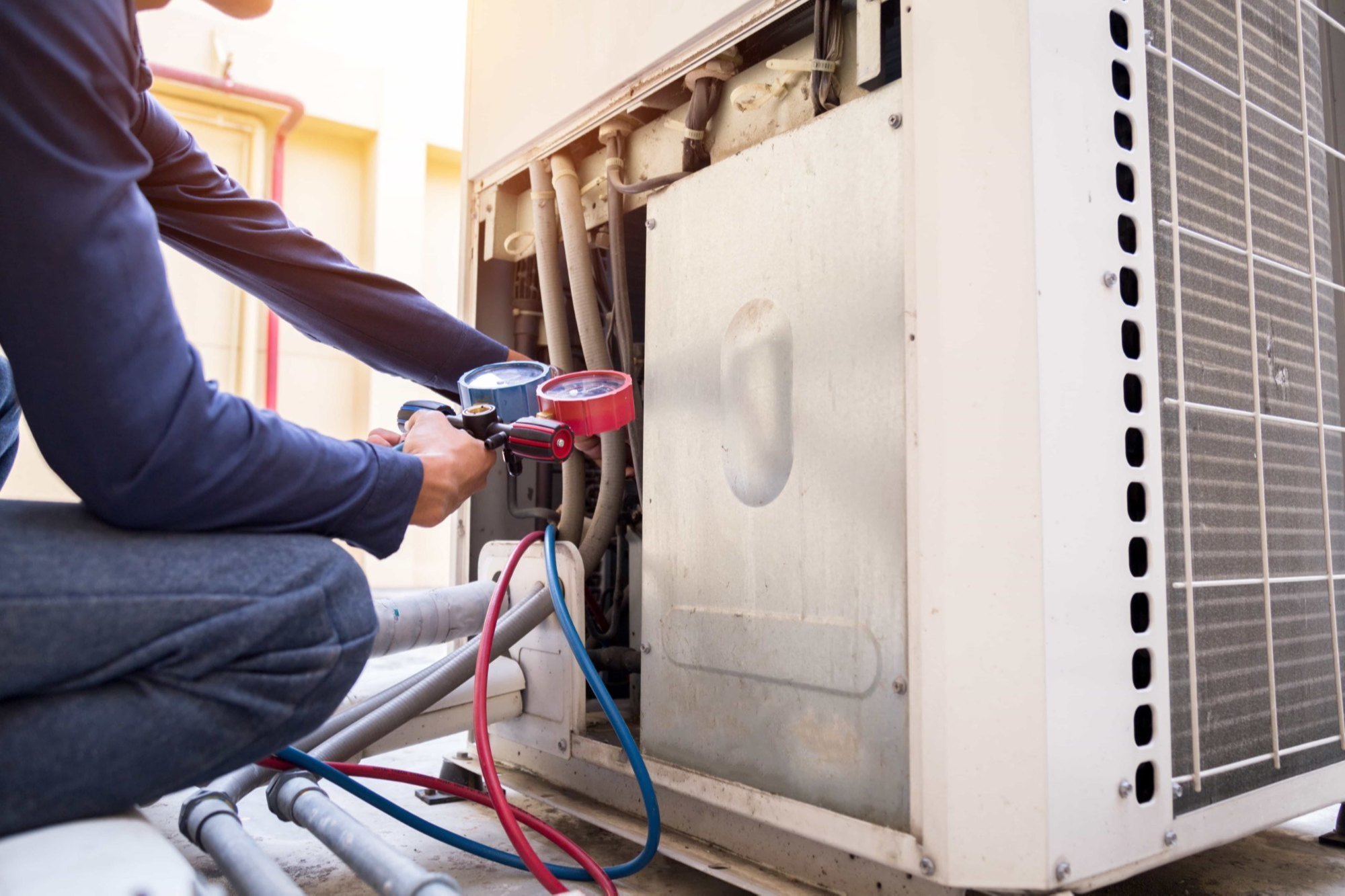 a person using a pressure gauge to check the air conditioner