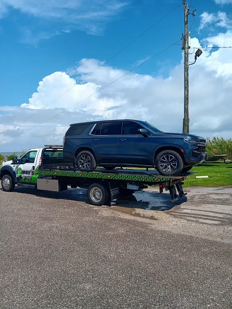 Gibby's Towing flatbed truck transporting black SUV in Mobile Alabama