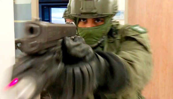 an israeli defense forces soldier pointing a semi-auto pistol at a target during combat