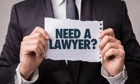 A man holding up a sign asking do you need a lawyer
