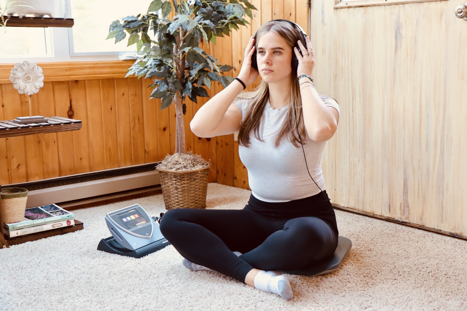 Woman sitting on PEMF mat while listening to a guided mediation Woman sitting on PEMF mat while listening to a guided mediation