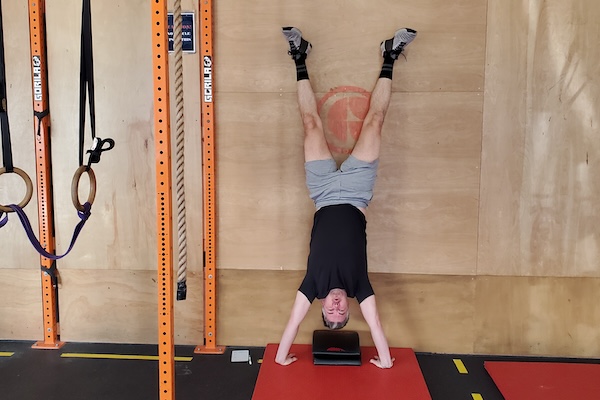 A man in a handstand hold against a wall A man in a handstand hold against a wall