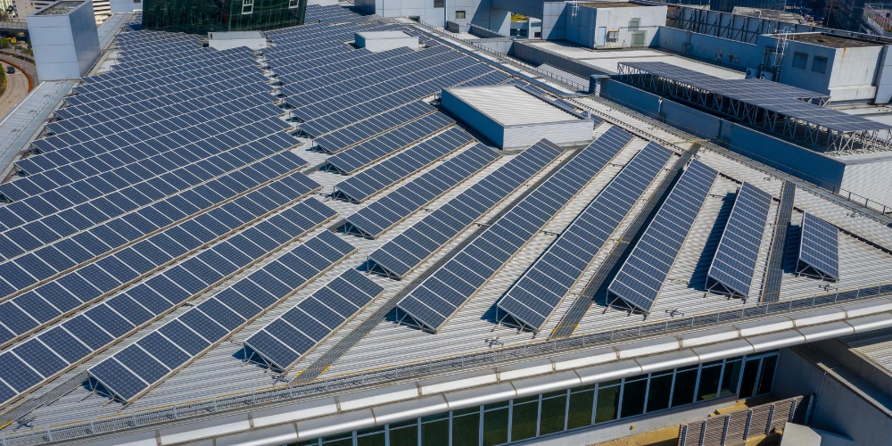 A large commercial solar system installation on a flat roof, with the panels utilising tilts to maximise their efficiency. A large commercial solar system installation on a flat roof, with the panels utilising tilts to maximise their efficiency.