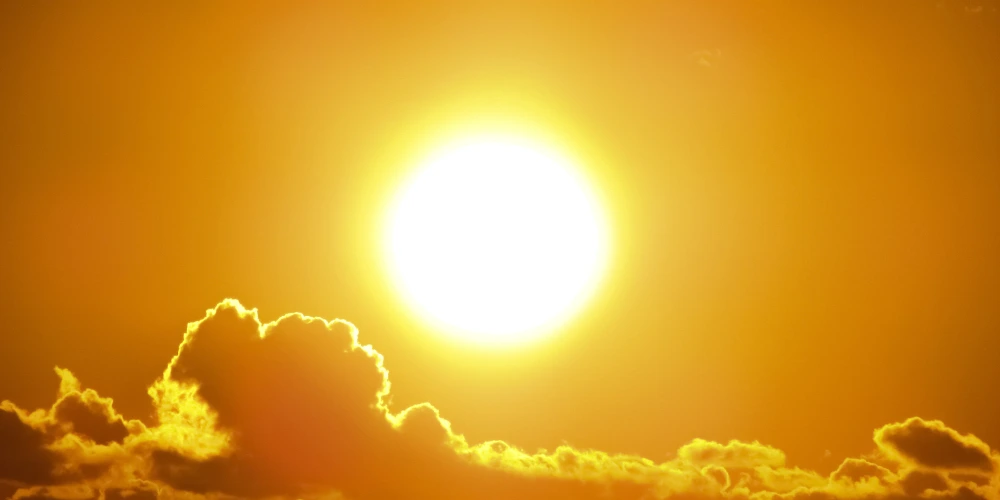 An image of the sun in the afternoon sky just before sunset with some clouds. An image of the sun in the afternoon sky just before sunset with some clouds.
