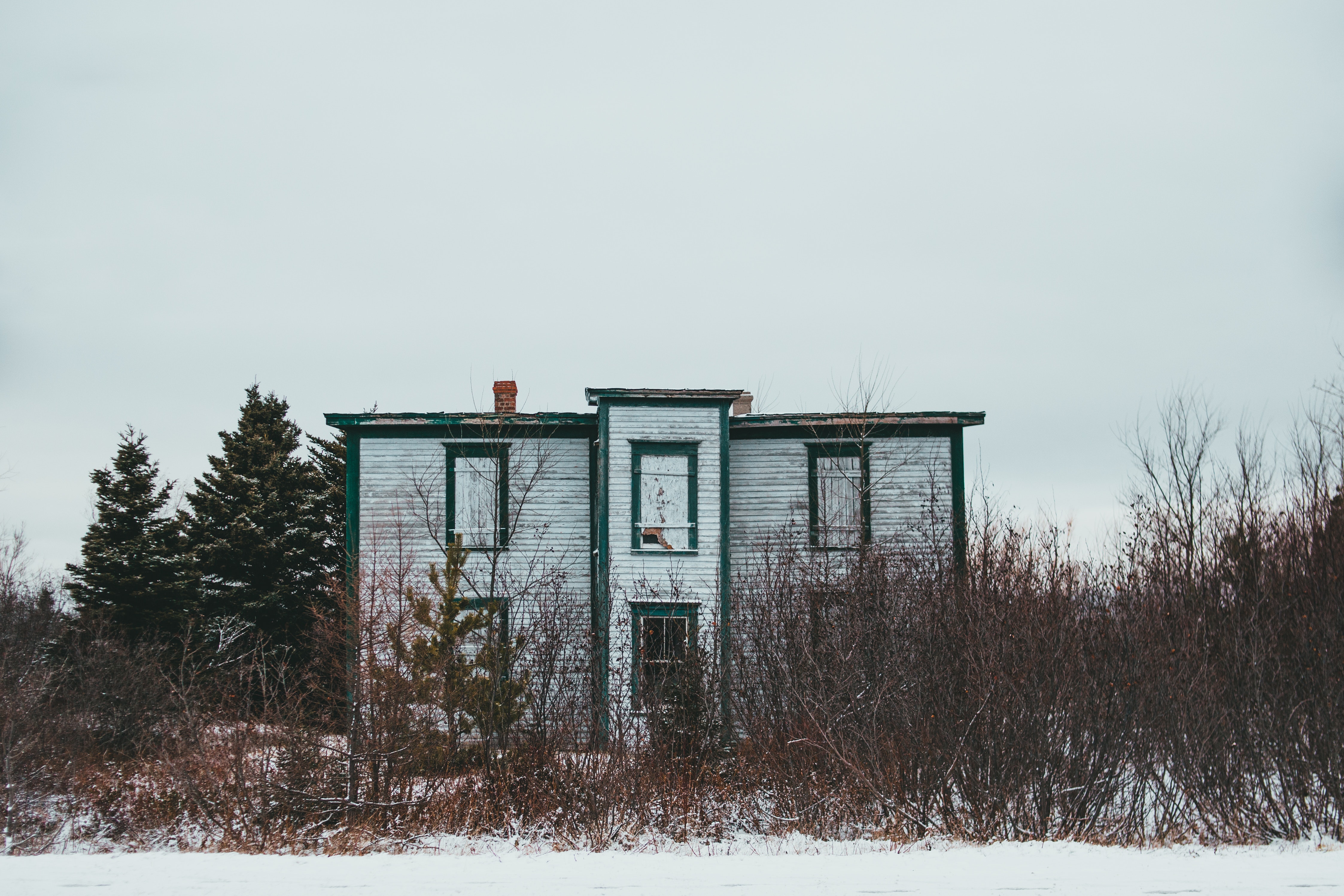 old abandoned building in snowy field.