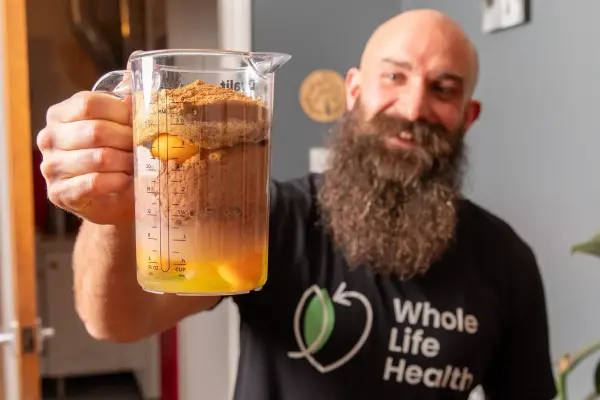 Nutrition Coach Jake holding a jug of healthy pancake batter Nutrition Coach Jake holding a jug of healthy pancake batter