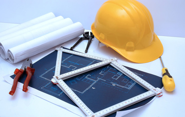 Construction gear and plans on a table. 