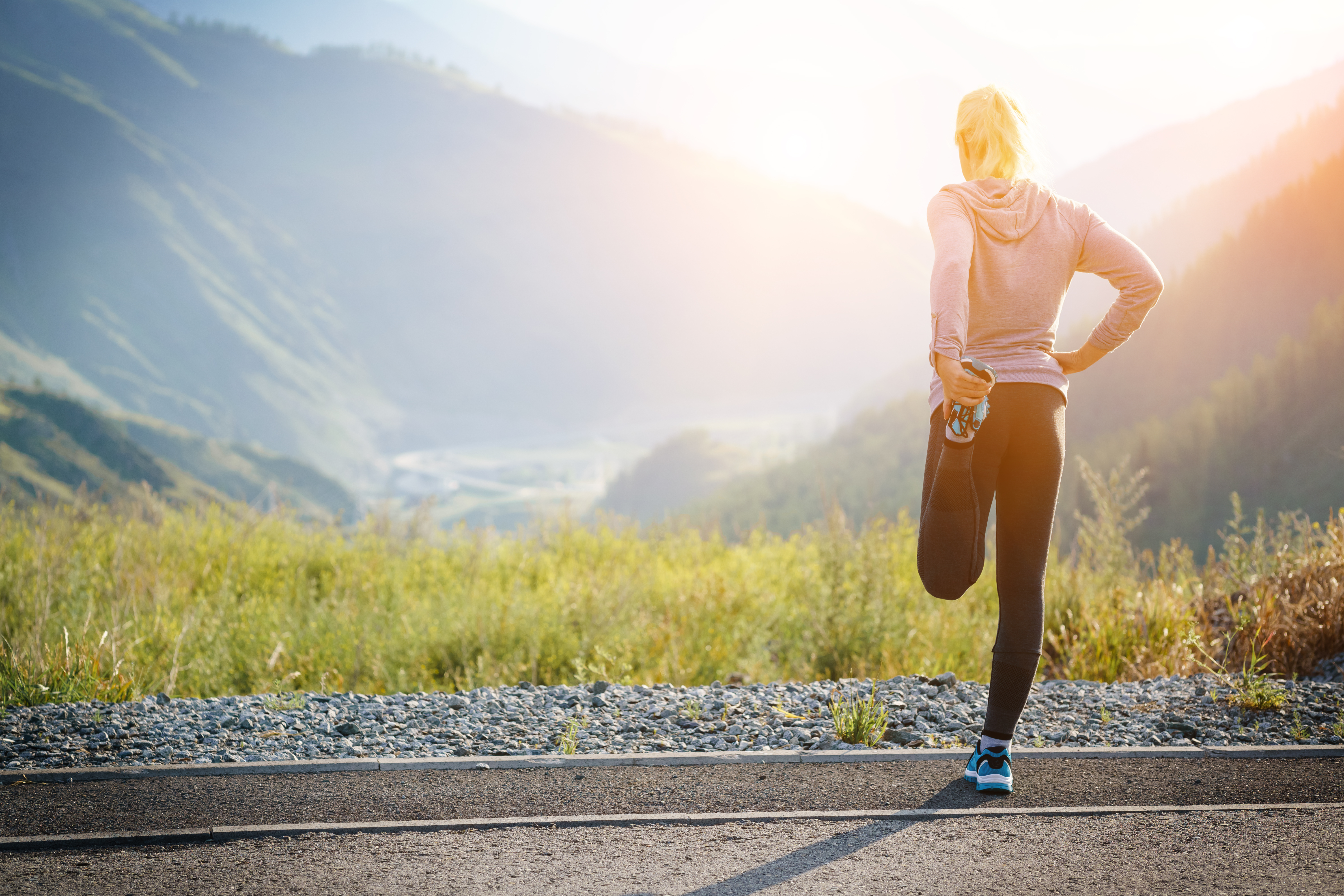 A woman stretching looking at the mountains