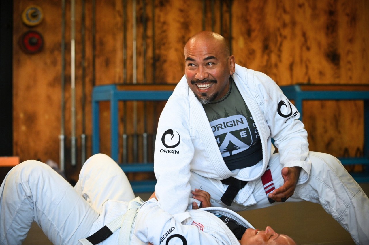 Martial arts instructor teaching adult BJJ class