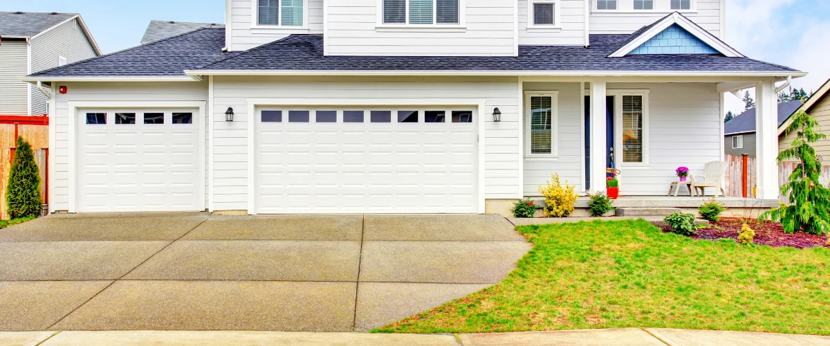 Modern white house with double garage and clean concrete driveway Modern white house with double garage and clean concrete driveway