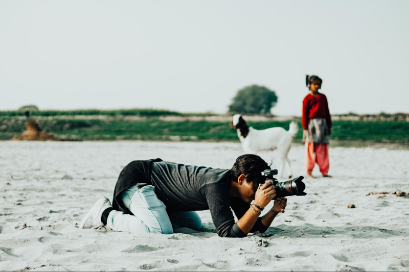 Kneeling in sand taking a shot