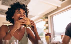 Women eating a hamburger in a restaurant.
