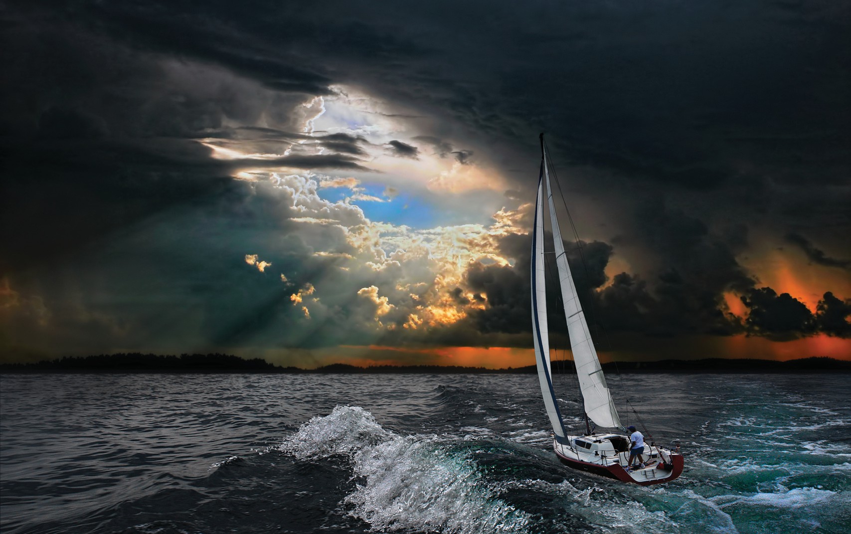Dark skies with a small patch of blue amidst the storm. Sail boat in the ocean aiming for the blue sky. 