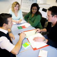 Adult learners working together in a team meeting.