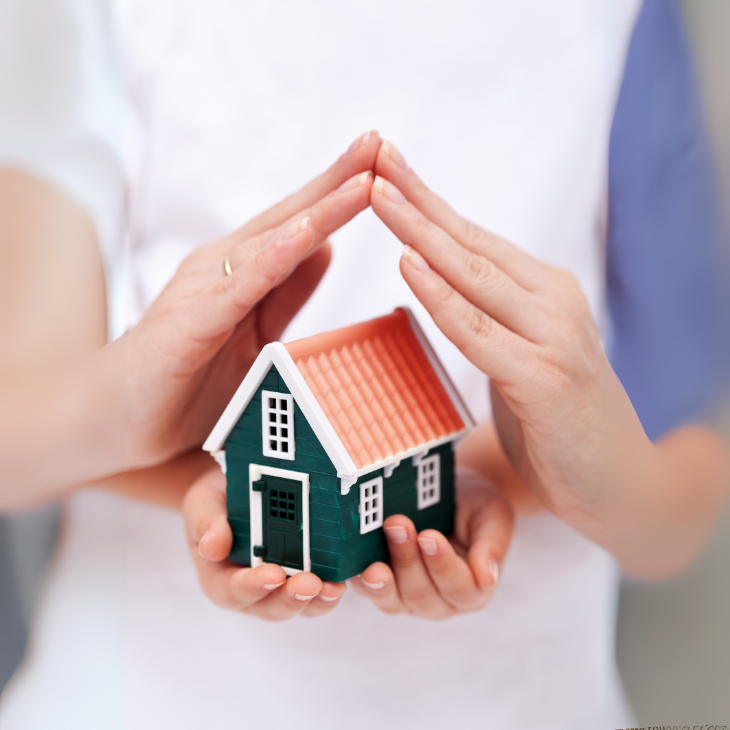 A hand held over a model home protecting it A hand held over a model home protecting it