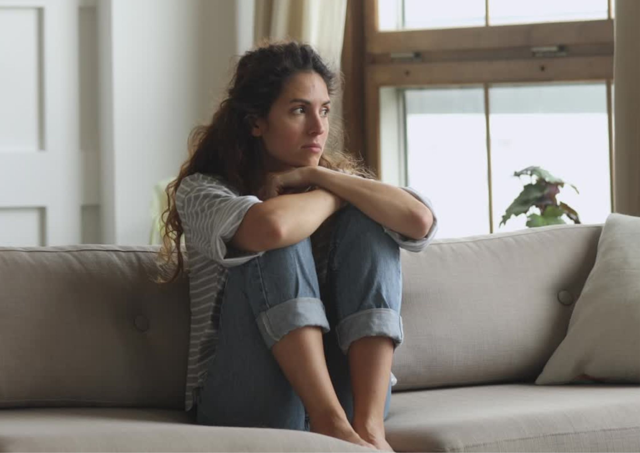 woman sitting on couch feeling overwhelmed