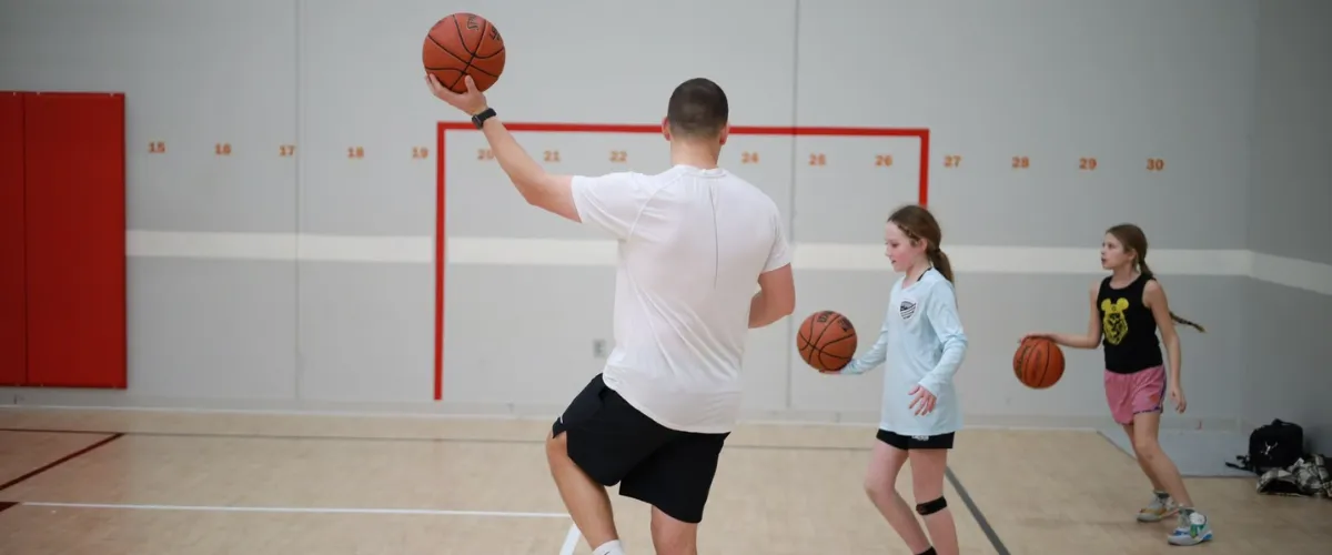 Basketball coach teaching young players ball control skills in Saint Charles Basketball coach teaching young players ball control skills in Saint Charles