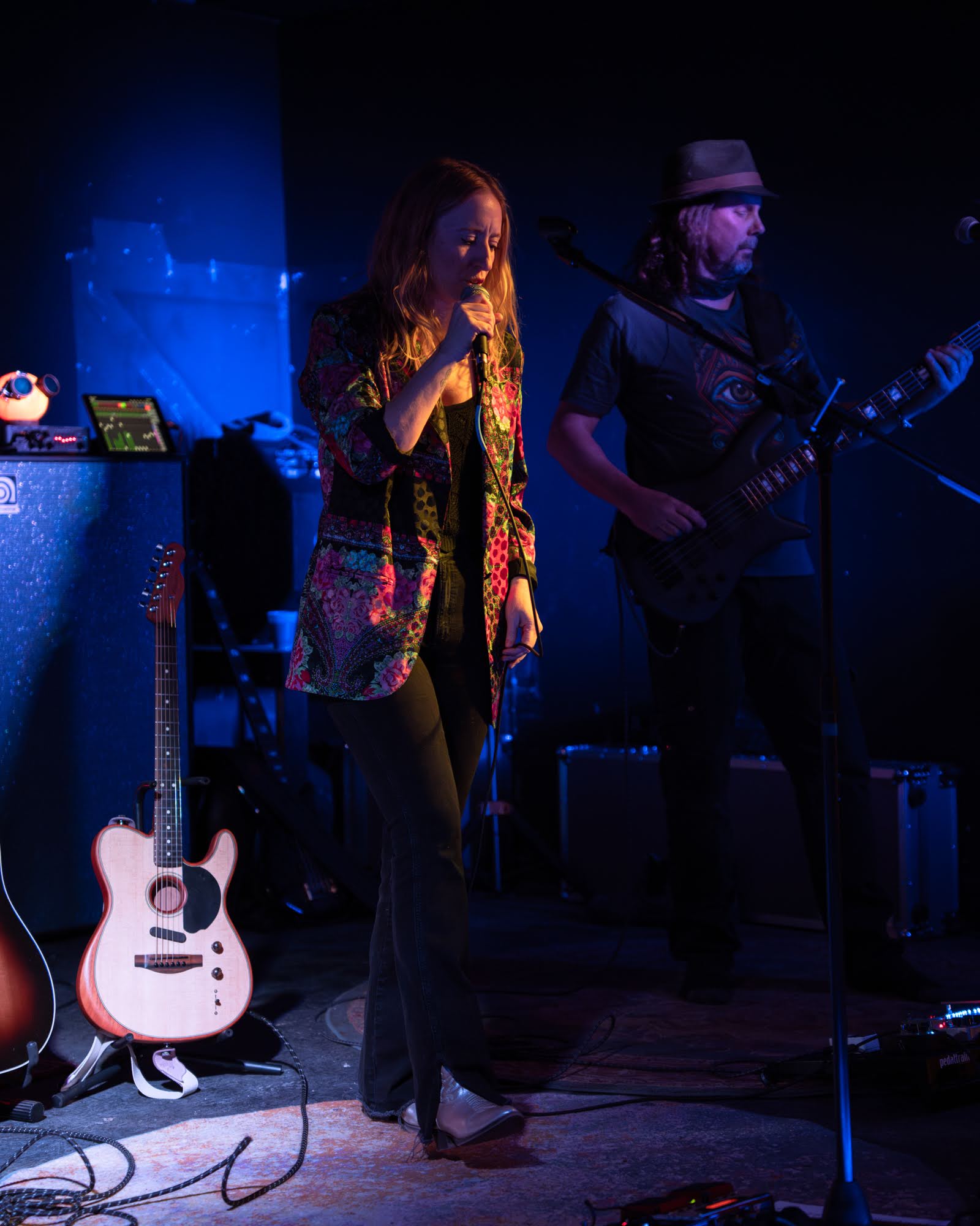 Jamie Wyman and Andy Belski on stage in a dark venue