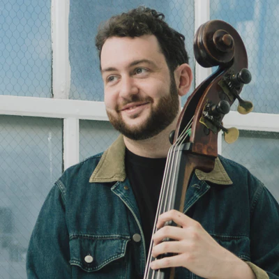 Cole Davis performing with upright bass in a moody studio