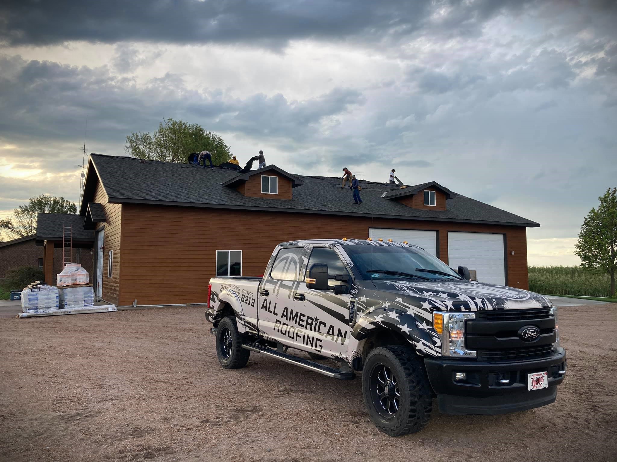 a truck in front of a house with shingle roofing