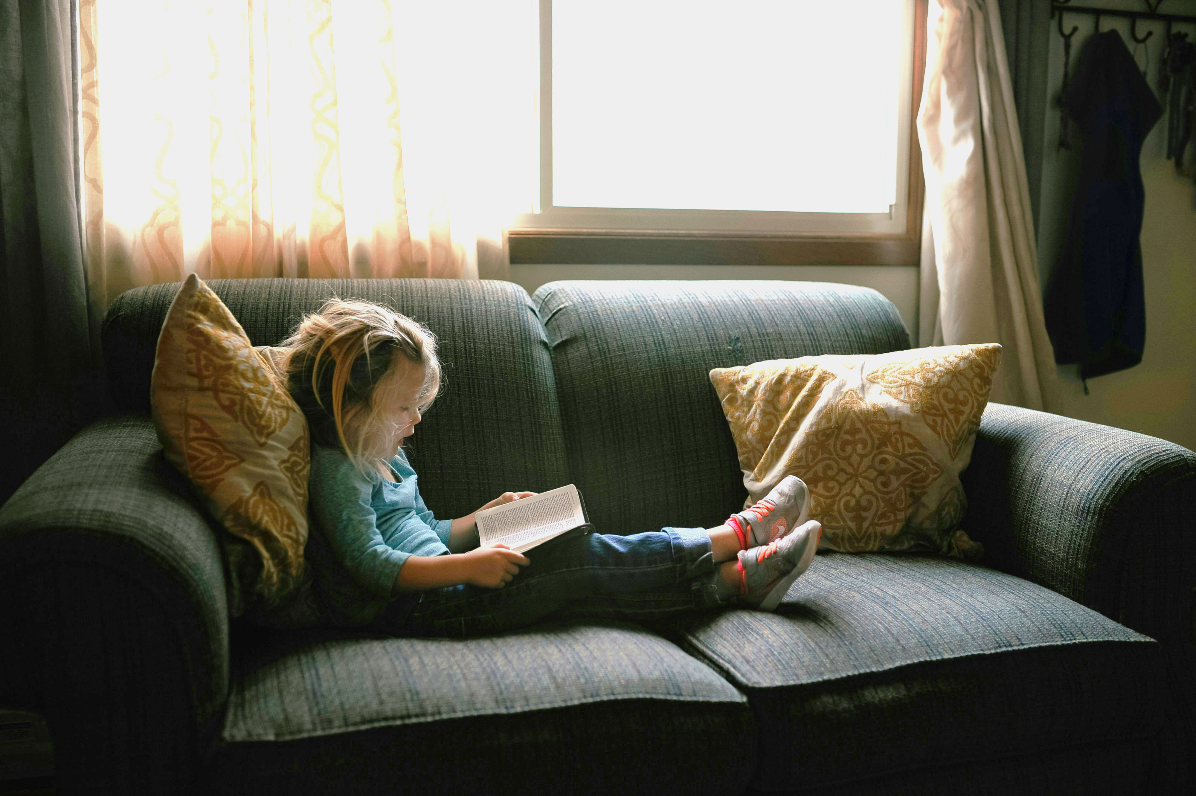 child reading on couch -Josh Applegate child reading on couch -Josh Applegate