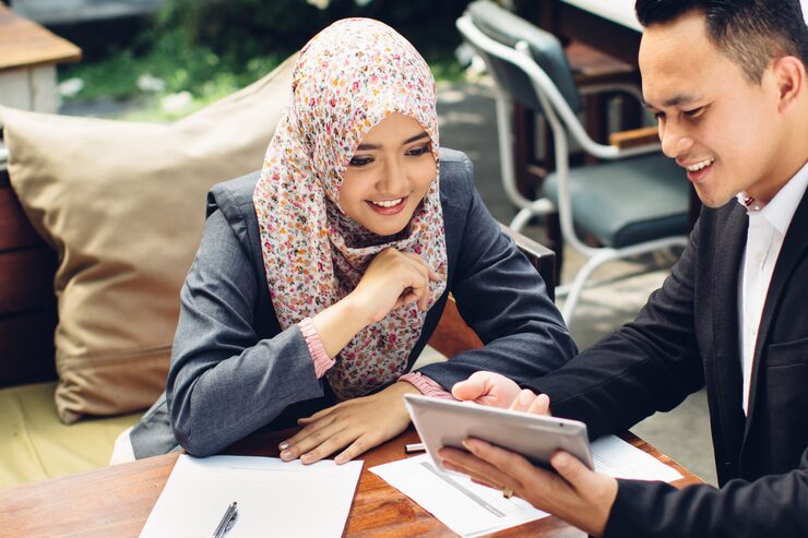 MuslimFin Family Office wealth adviser analyzing financial documents with a client 