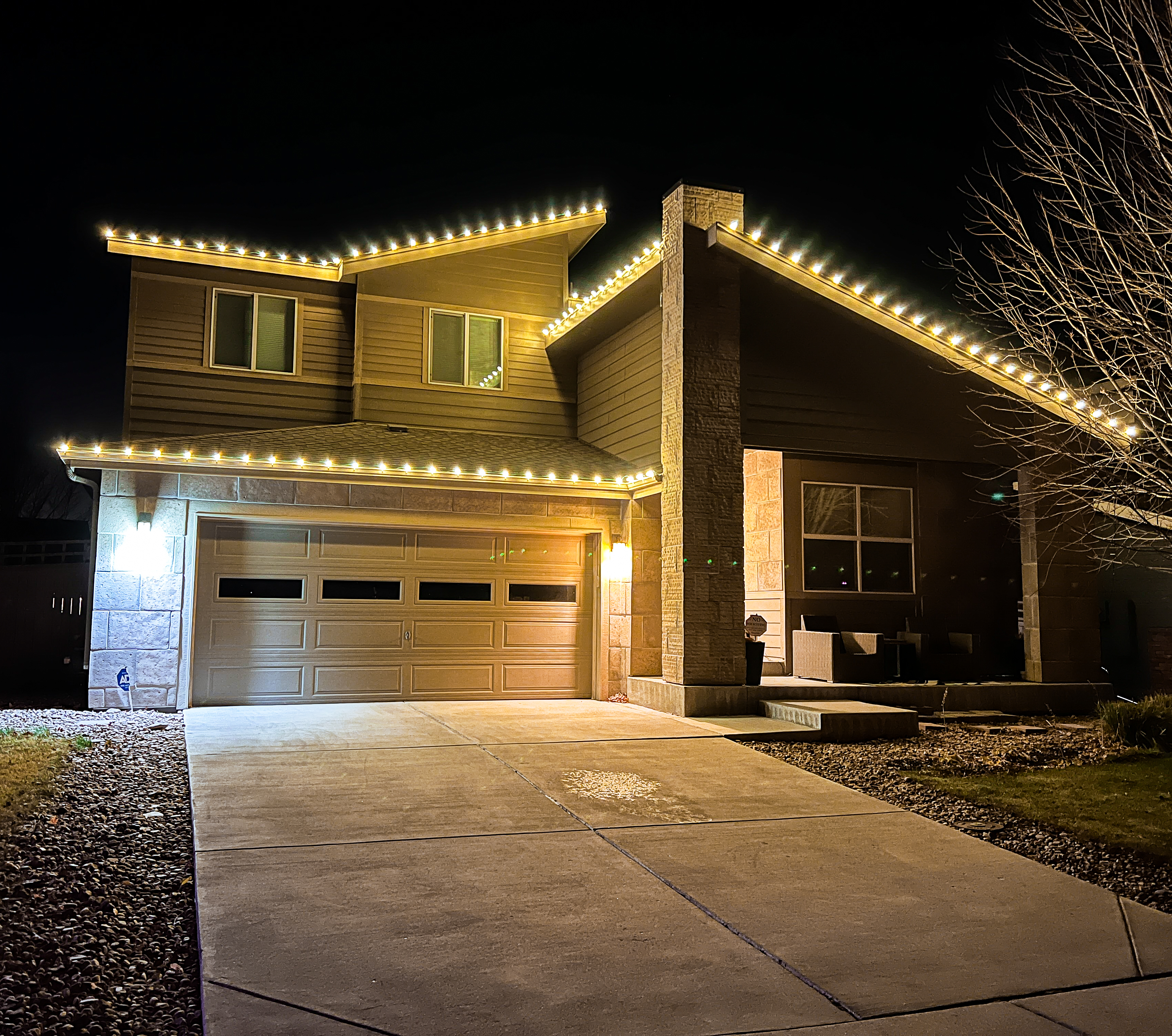 Cozy warm white roofline Christmas lights installed on a Timnath home