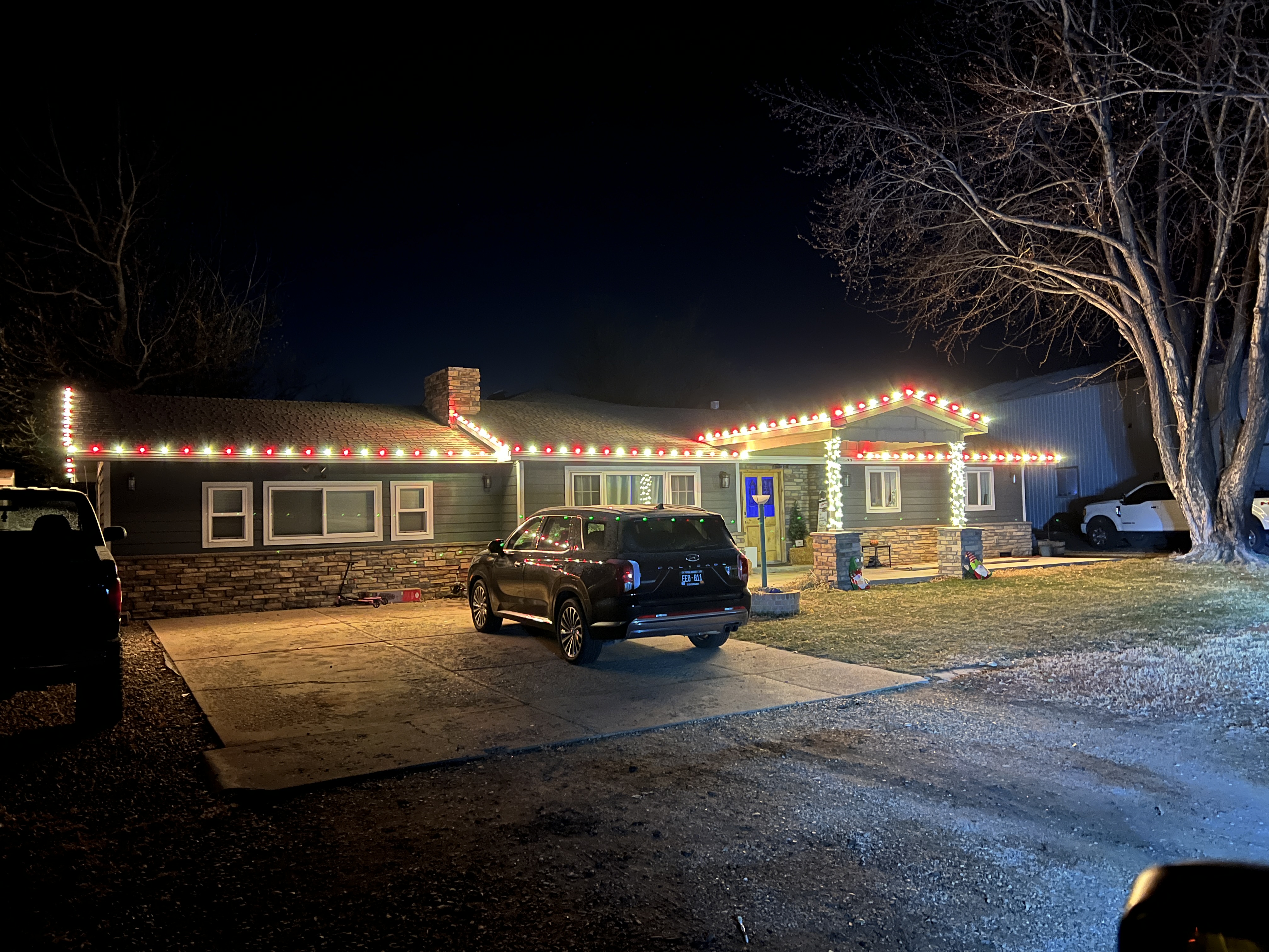 Elegant warm white and red C9 LED Christmas lights installed on a Loveland home