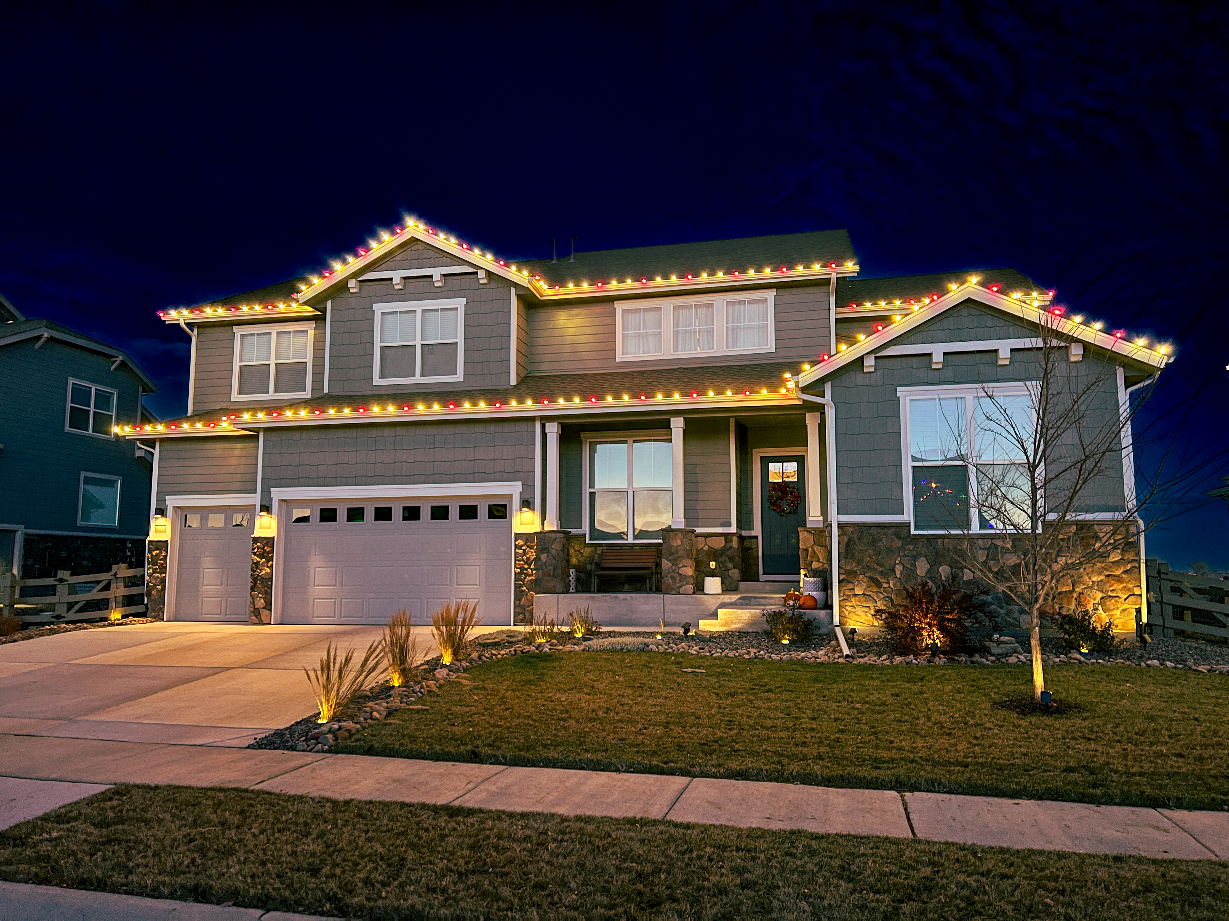 Professional Christmas light installation in Loveland featuring warm white and red commercial-grade C9 bulbs on residential home exterior