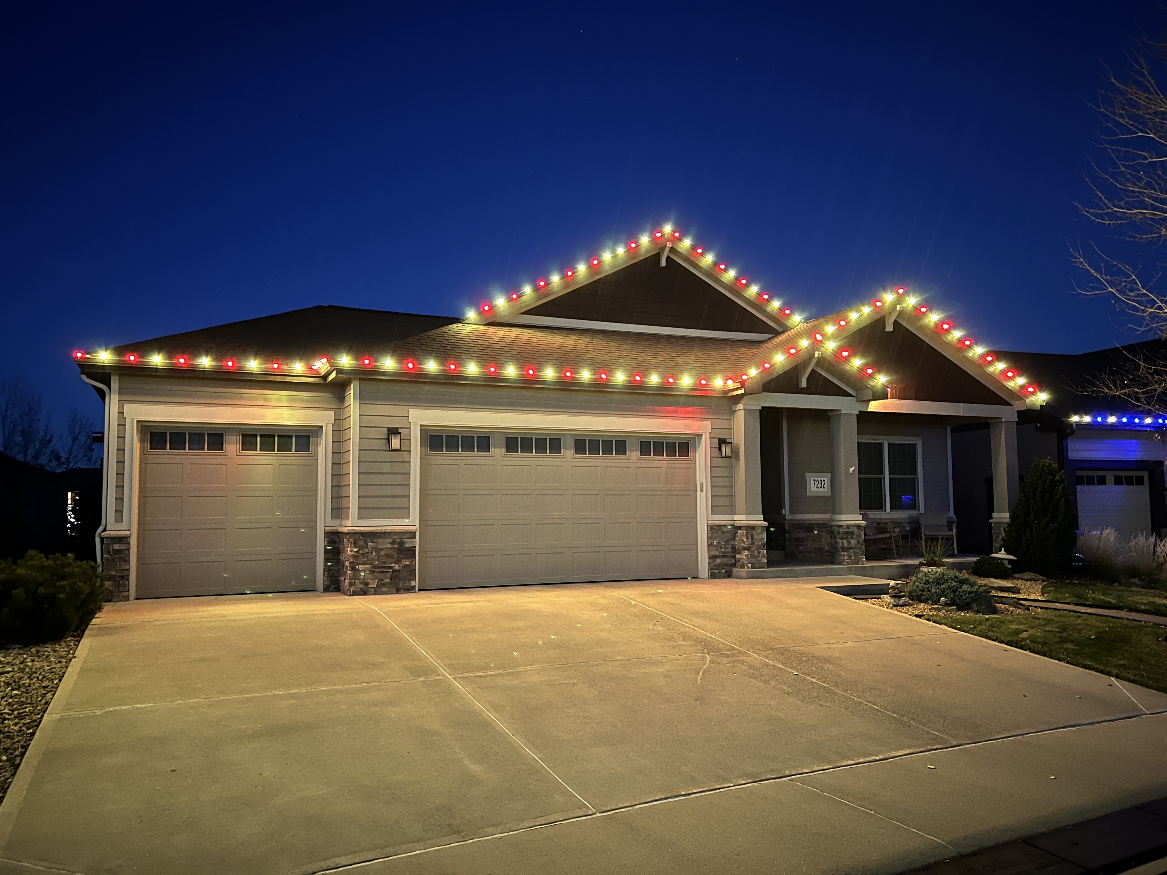 Professional Christmas light installation in Windsor featuring warm white and red commercial-grade C9 bulbs on residential home exterior