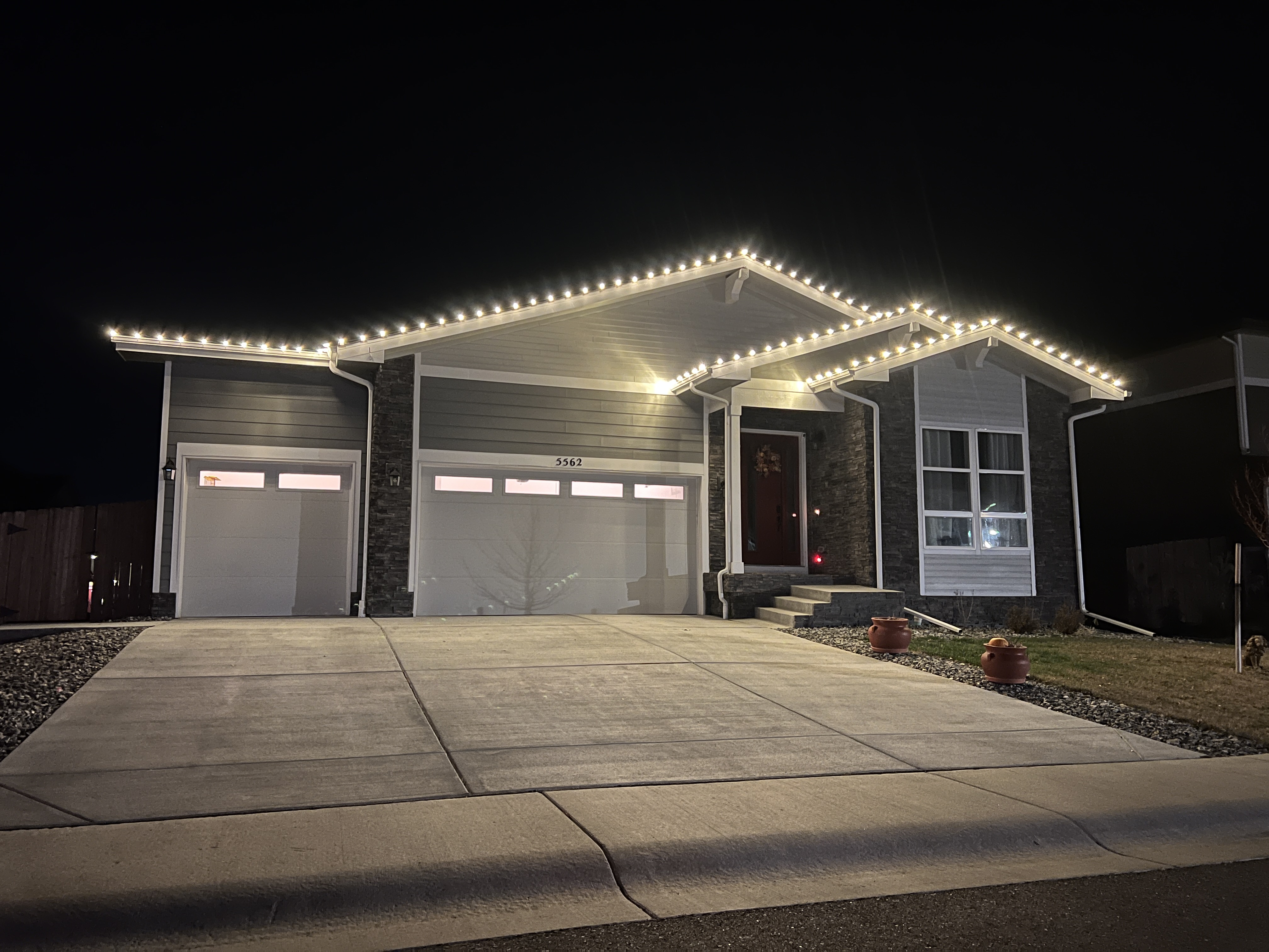 Bright cool white Christmas lights installation on Windsor home using commercial-grade C9 LED bulbs for modern holiday lighting