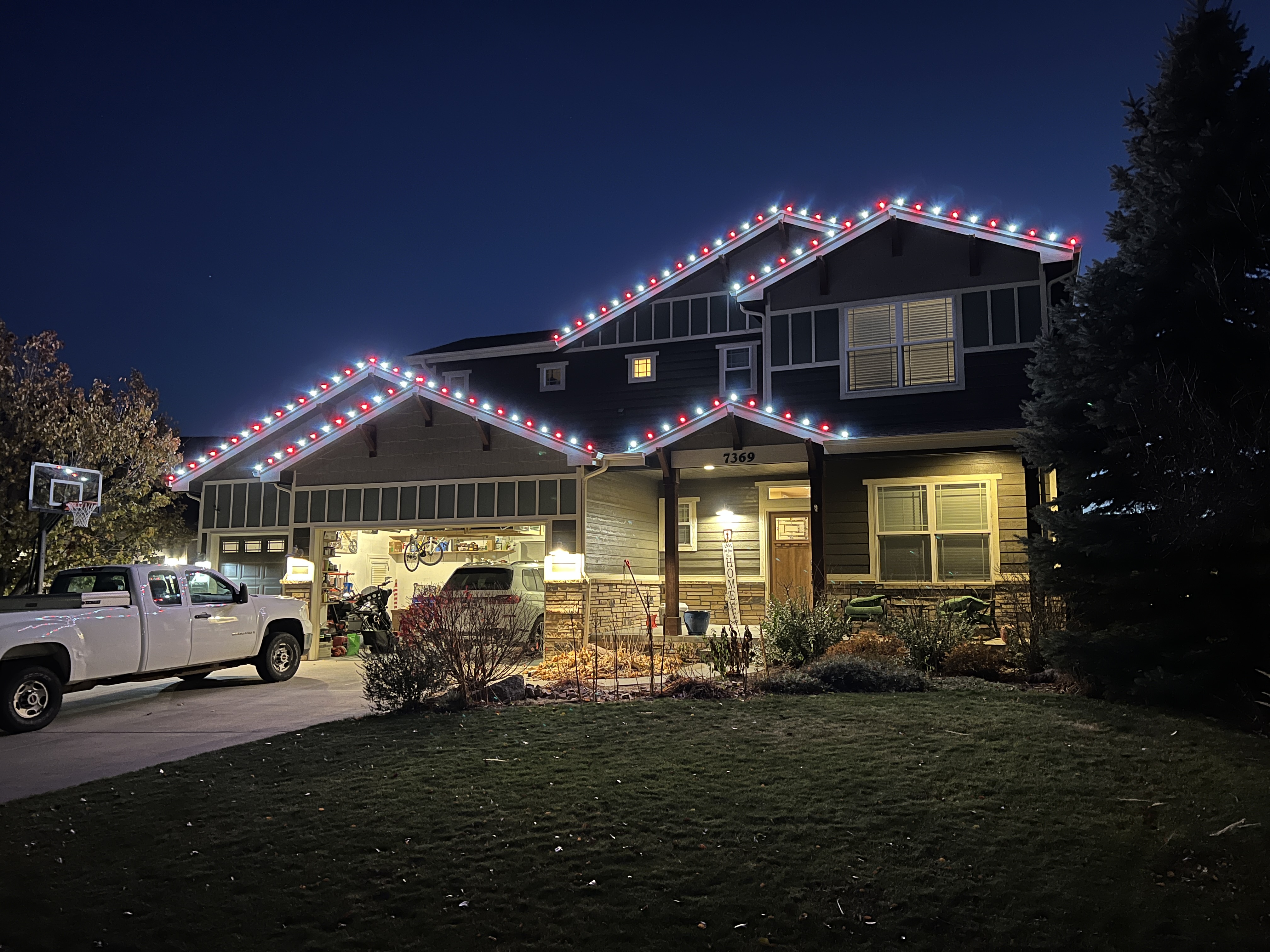 Cool white and red C9 LED Christmas lights installed on a Windsor home