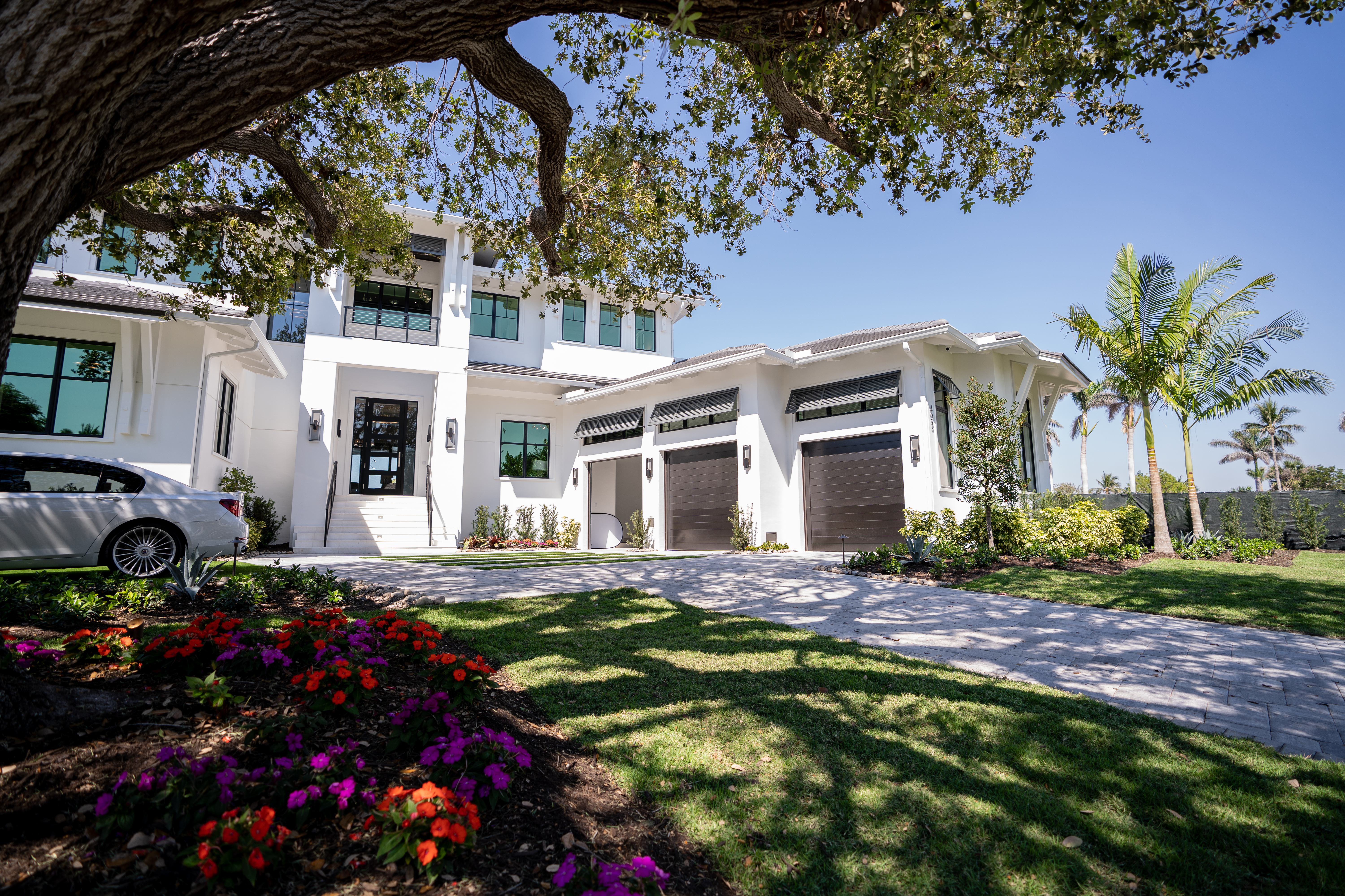 Exterior view of $16 million villa in Naples, FL with palm trees and modern architecture