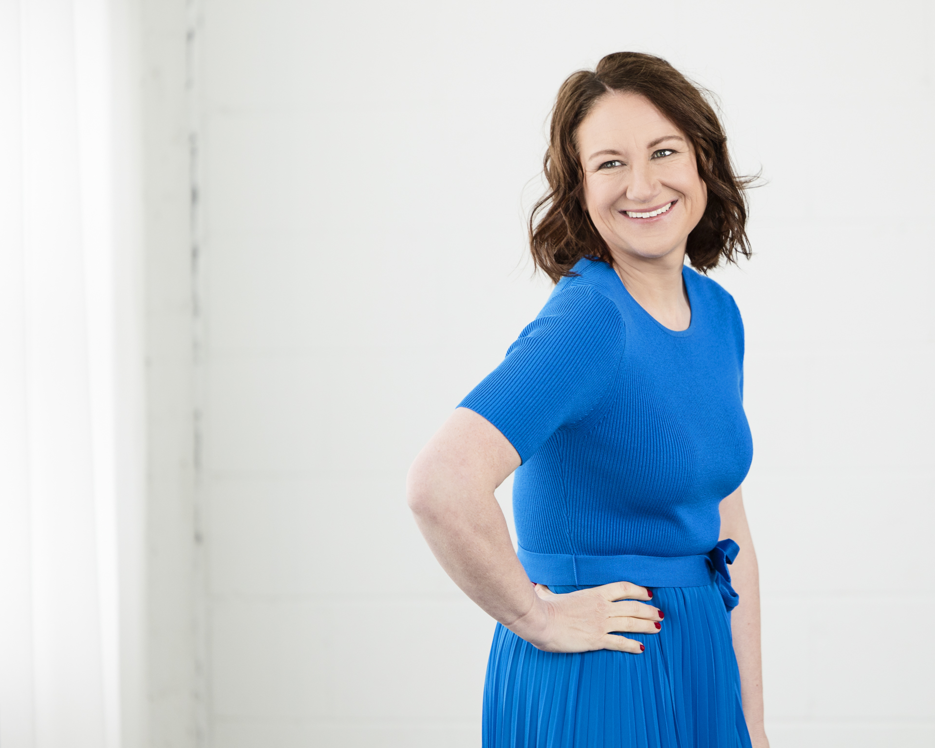 Portrait of a lady wearing a blue dress and her hand on her hip Alison McWhirter Photography Personal Branding Photography