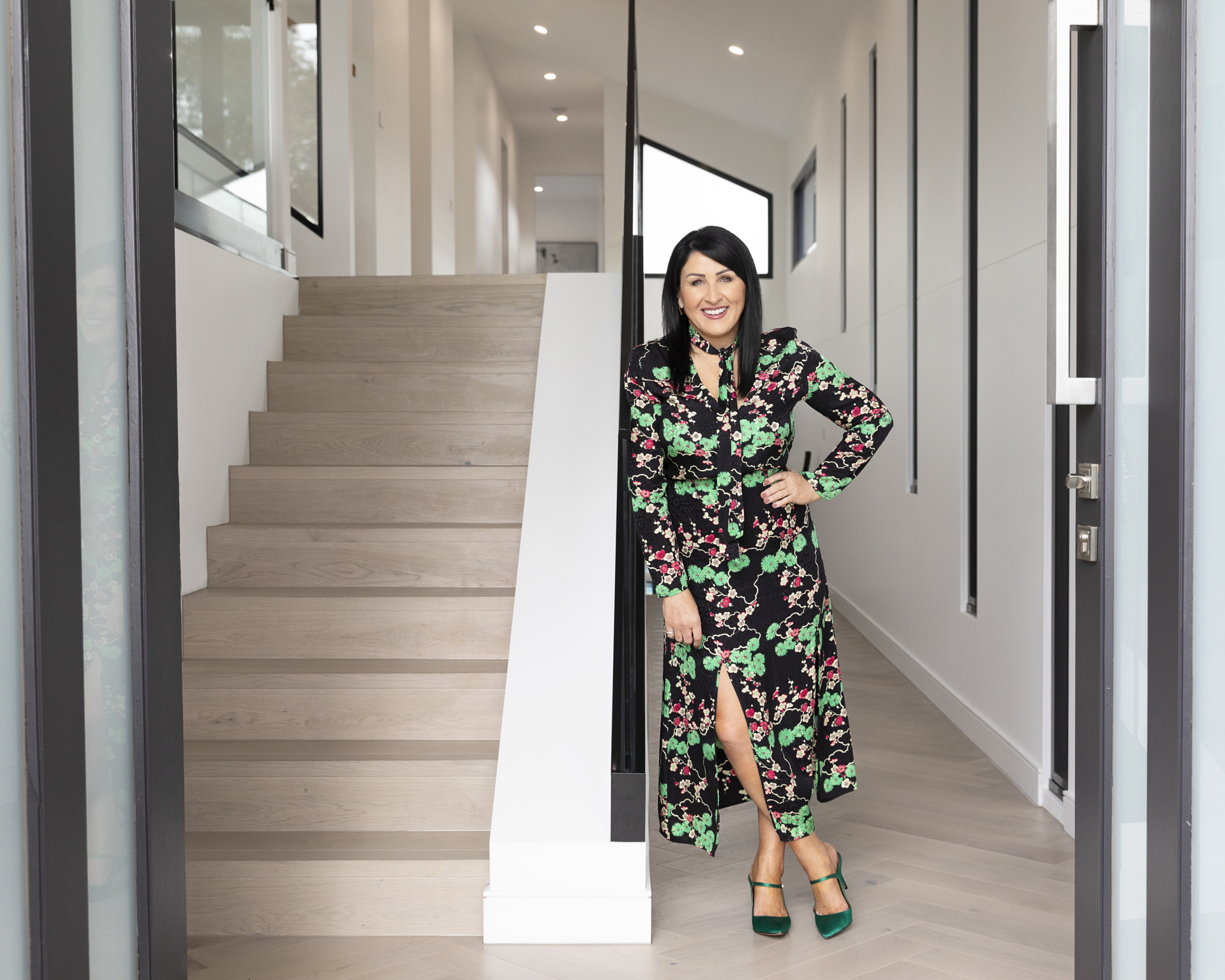 Personal branding image of a lady in a floral dress leaning against a flight of stairs