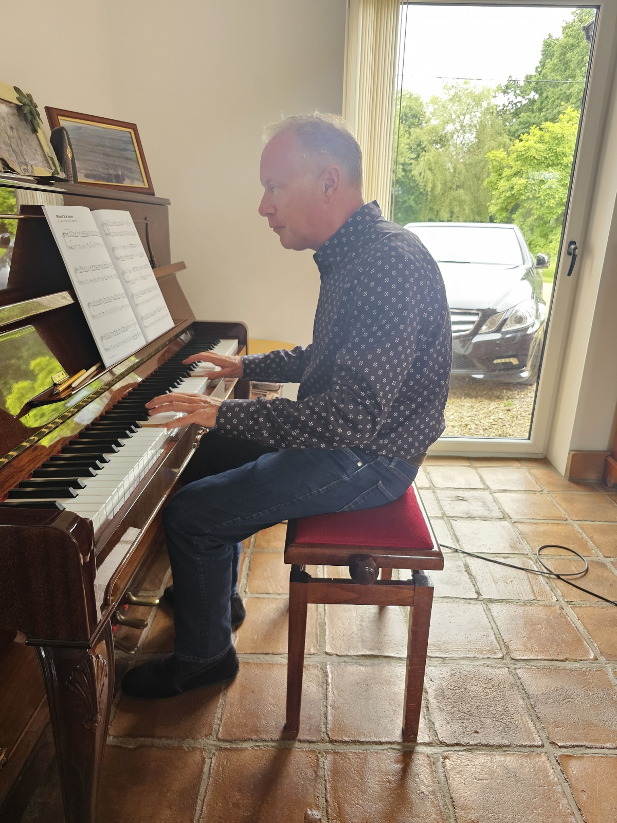 A Man playing an acoustic upright piano A Man playing an acoustic upright piano