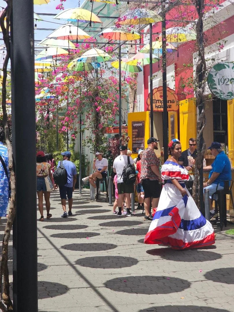 Authentic Dominican street with colorful homes and locals interacting naturally. Authentic Dominican street with colorful homes and locals interacting naturally.