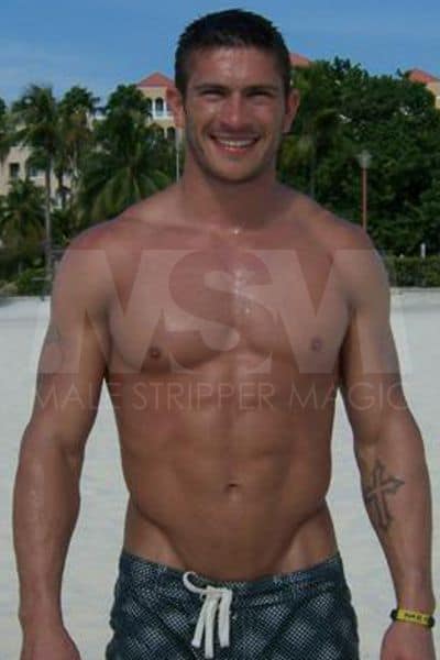 Male stripper Jay on beach, shirtless, muscular, wearing swim trunks