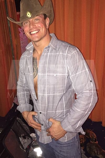Male stripper Dean beaming with joy, dressed as a cowboy for a bacheloreete party