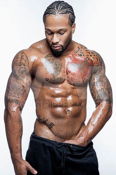 Black male stripper Pleasure shirtless, wearing cornrows and black sweatpants