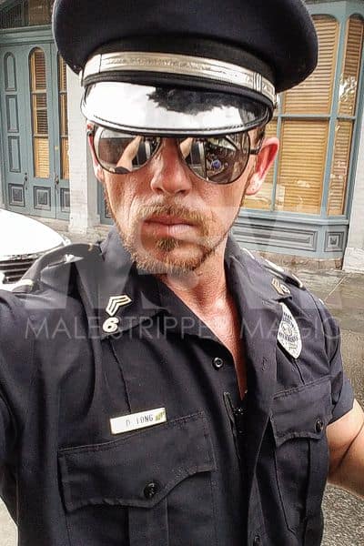 Male stripper Sebastian on Bourbon Street wearing a cop costume