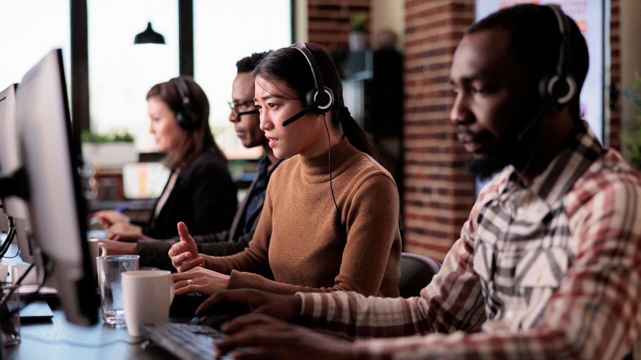 Customer support team using headsets and computers, illustrating remote IT assistance environment Customer support team using headsets and computers, illustrating remote IT assistance environment