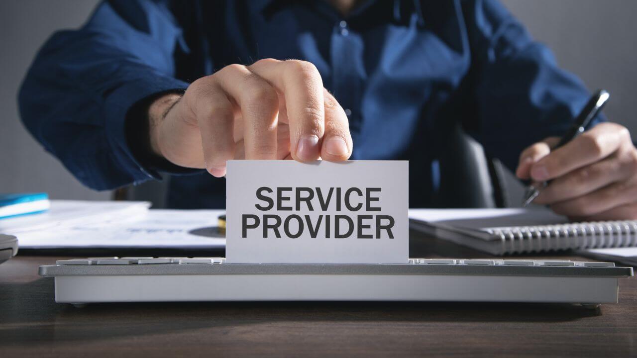 Businessman holding service provider sign above keyboard, highlighting MSP responsibility in cybersecurity defense Businessman holding service provider sign above keyboard, highlighting MSP responsibility in cybersecurity defense
