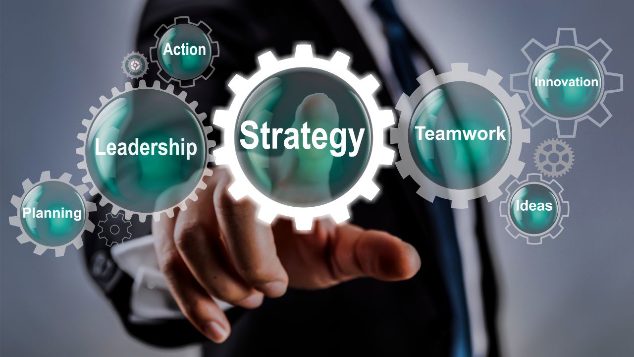 `Businessman pointing at virtual gears with keywords like strategy, leadership, teamwork, and innovation for cybersecurity alignment` `Businessman pointing at virtual gears with keywords like strategy, leadership, teamwork, and innovation for cybersecurity alignment`