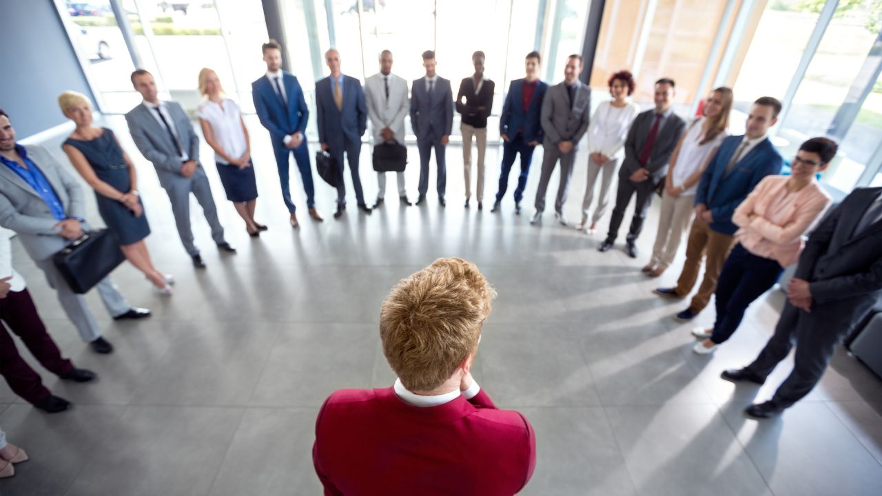 Business leader addressing executives in a corporate lobby, representing strategic leadership and enterprise decision-making. Business leader addressing executives in a corporate lobby, representing strategic leadership and enterprise decision-making.