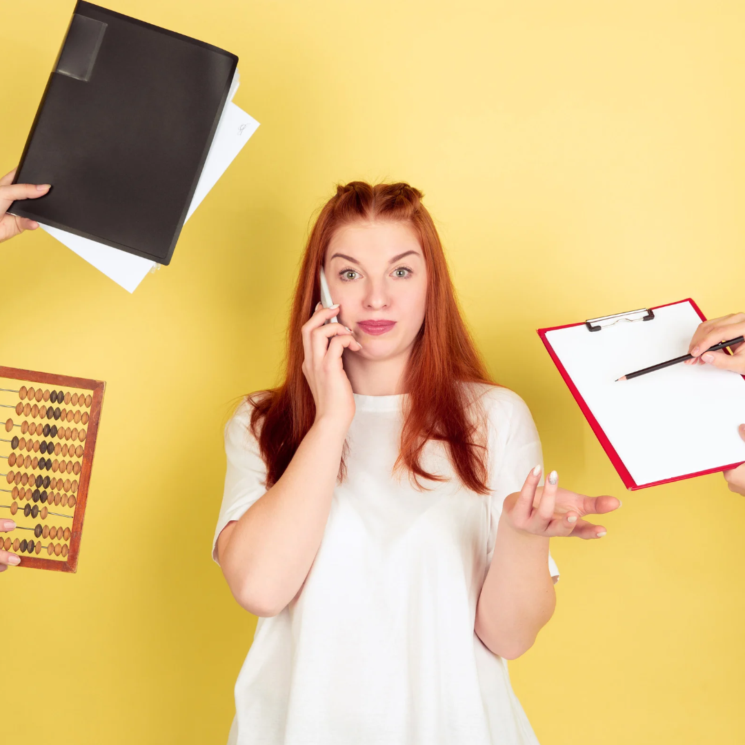 a woman talking on a cell phone while holding a clipboard.