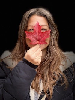 A quiet moment of vulnerability - a woman half-hidden behind a leaf, meeting the world with soft, open eyes. A quiet moment of vulnerability - a woman half-hidden behind a leaf, meeting the world with soft, open eyes.