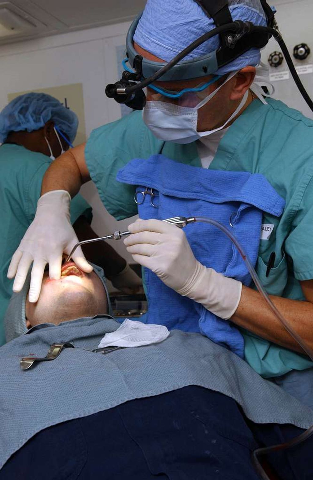 Dentist removing wisdom tooth from teenage patient