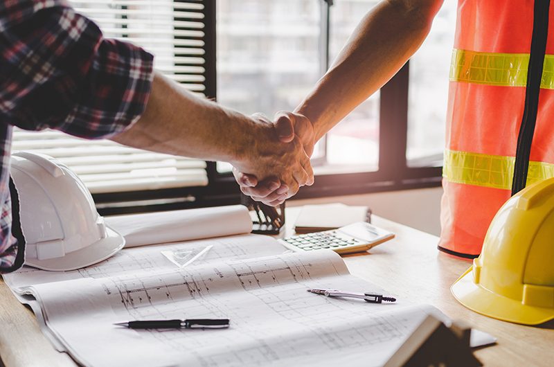 professional worker and client shakes hand on construction work