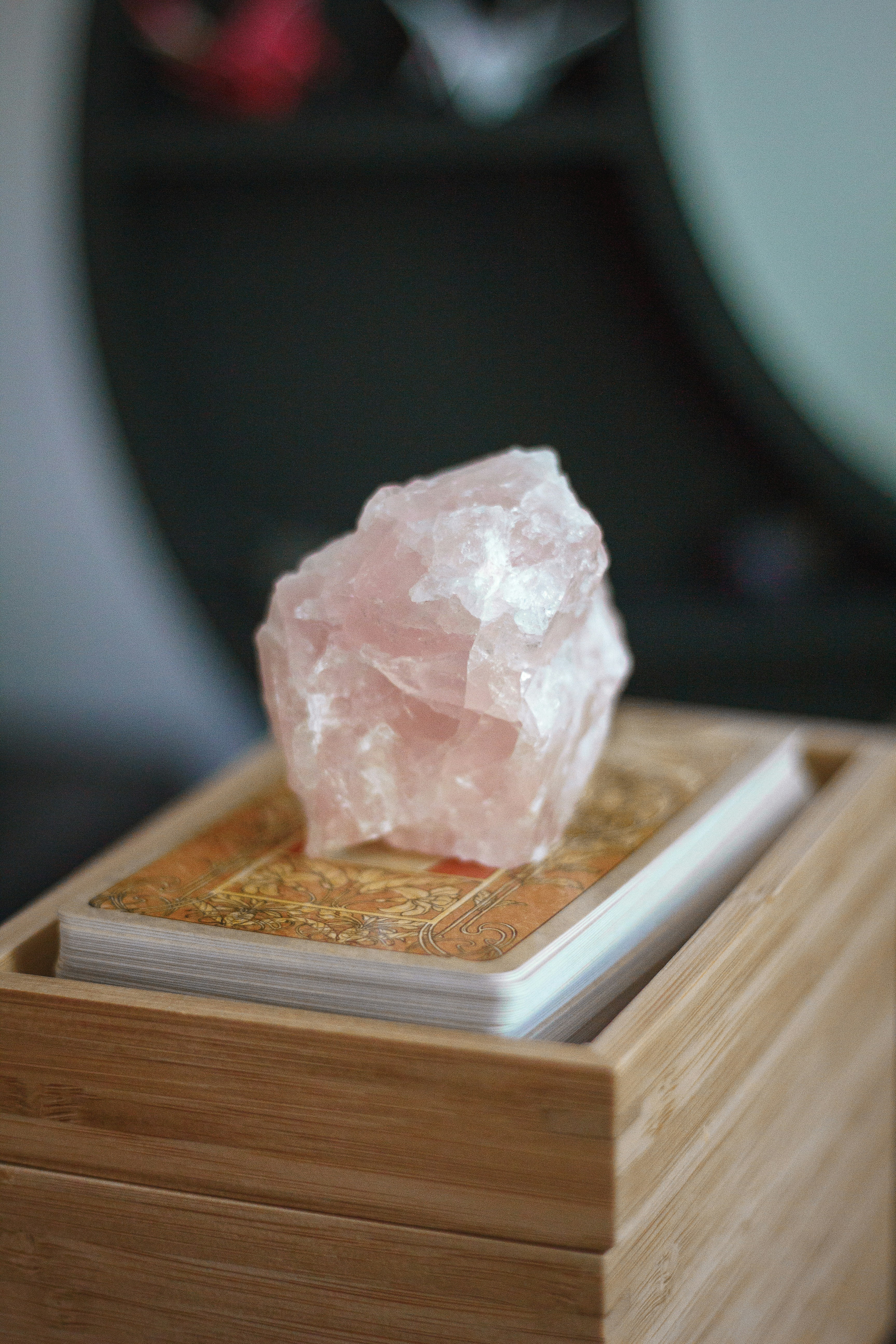 rose quartz on top of a tarot card deck